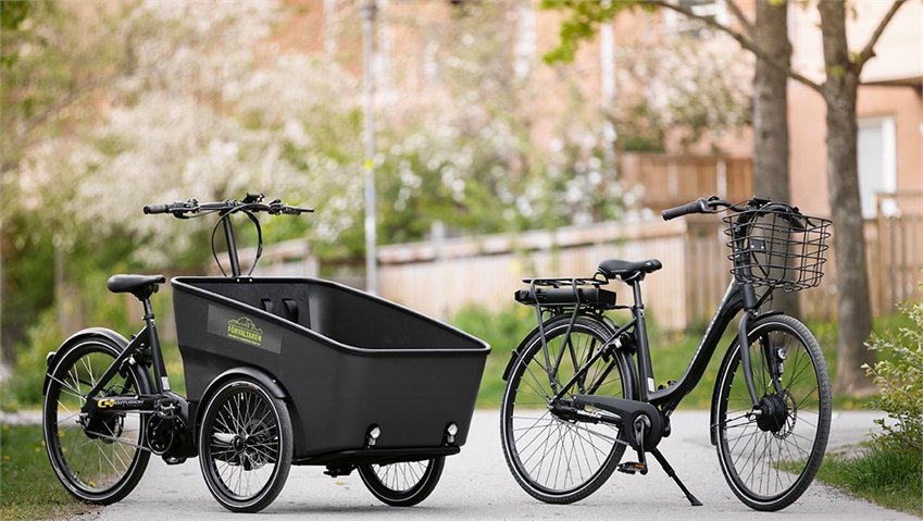 cyklar från cykelpoolen uppställda på cykelväg sommartid