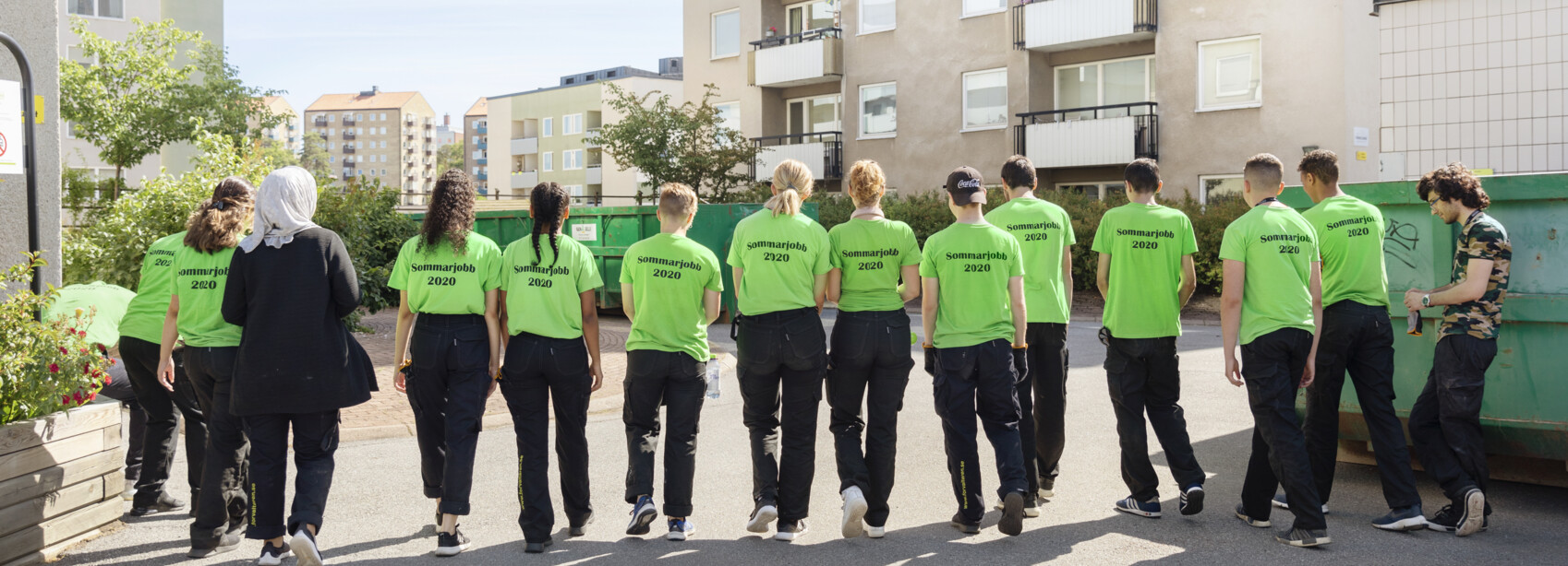 ett gäng sommarjobbare prommenerar. Bild tagen mot ryggar och på tröjorna står Sommarjobb 2020